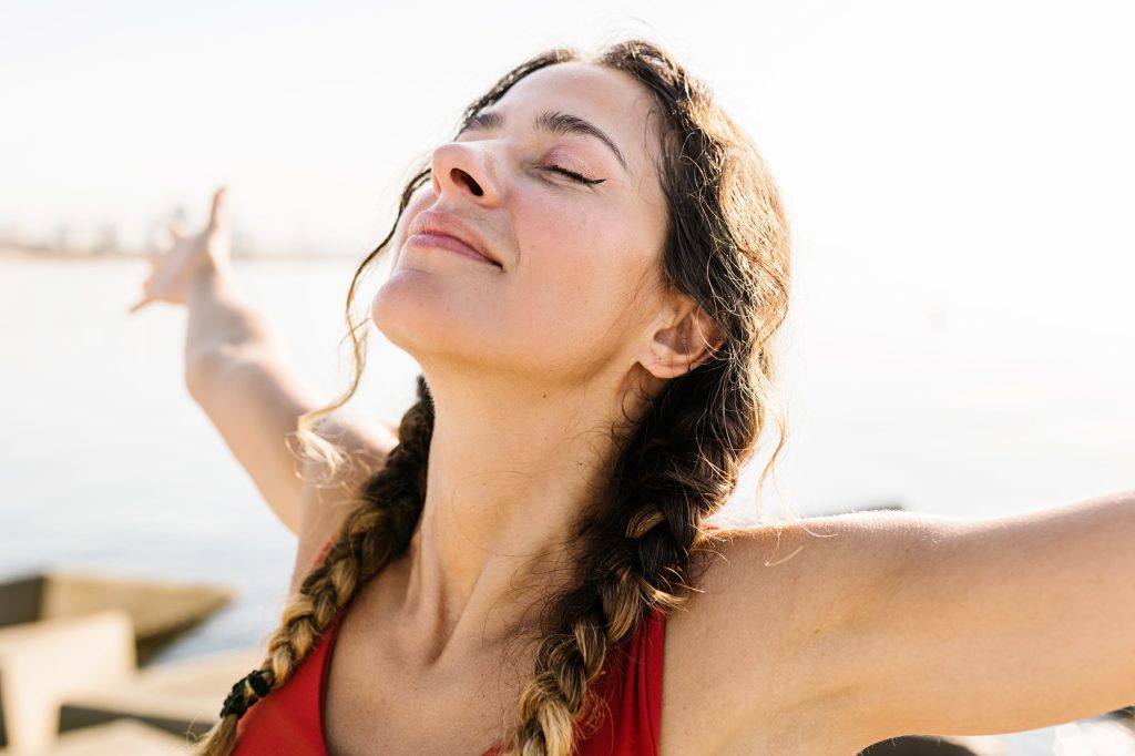 Woman breathing fresh air standing on the beach at summer